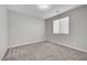 Neutral bedroom with carpet, base molding, window with blinds, and standard ceiling light at 10142 Skye Saddle Ave, Las Vegas, NV 89166