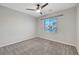 Bedroom with neutral carpet, a ceiling fan, and a window overlooking the neighborhood at 10142 Skye Saddle Ave, Las Vegas, NV 89166