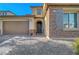 Inviting front entry with stone accents, arched doorway and a two-car garage at 10142 Skye Saddle Ave, Las Vegas, NV 89166