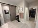 Stylish hallway with a sliding barn door, tile flooring, and access to a closet with custom shelving at 10142 Skye Saddle Ave, Las Vegas, NV 89166