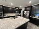 Spacious kitchen featuring dark cabinetry, stainless steel appliances, and a large island with granite countertops at 10142 Skye Saddle Ave, Las Vegas, NV 89166