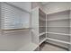 Laundry room shelves provide ample storage; a window lets in natural light at 10142 Skye Saddle Ave, Las Vegas, NV 89166