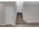 Carpeted staircase with white walls and a white door, showcasing the home's entryway at 10142 Skye Saddle Ave, Las Vegas, NV 89166