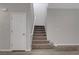 Carpeted staircase with white walls and a white door, showcasing the home's entryway at 10142 Skye Saddle Ave, Las Vegas, NV 89166