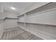 Spacious walk-in closet with carpet and wooden bars for hanging clothes and shelves at 10142 Skye Saddle Ave, Las Vegas, NV 89166