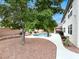 Landscaped backyard featuring a pool, mature trees, gravel, and privacy fence at 10392 Smokemont Ct, Las Vegas, NV 89129