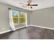 An airy bedroom features hardwood floors, neutral walls, ceiling fan, and bright windows with a view at 10392 Smokemont Ct, Las Vegas, NV 89129