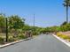 Gated community entrance with landscaped median, mature trees, and concrete drive at 10392 Smokemont Ct, Las Vegas, NV 89129