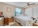 Bedroom with carpet flooring, ceiling fan, and a window with blue sheer curtains at 107 Elm St, Henderson, NV 89015
