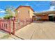 View of the exterior featuring a desert landscaped yard behind a decorative iron fence and covered driveway at 107 Elm St, Henderson, NV 89015