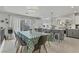 Light and bright dining area with a large table, modern chandelier, and views into the kitchen at 11009 Pentland Downs St, Las Vegas, NV 89141
