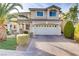 Charming two-story home with a tile roof, manicured landscaping, and a brick driveway at 11009 Pentland Downs St, Las Vegas, NV 89141