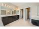 Bathroom featuring double vanity, dark cabinets, and large mirror at 12296 Kings Eagle St, Las Vegas, NV 89141