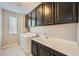 Well-lit laundry room featuring a front-load washer and dryer, with dark cabinetry above, and a bright, clean utility sink and workspace at 12296 Kings Eagle St, Las Vegas, NV 89141