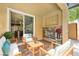 Cozy covered patio with comfortable seating, a stone fireplace, and views into the home's interior at 12296 Kings Eagle St, Las Vegas, NV 89141