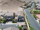Beautiful aerial view of a two-story home with a tile roof, desert landscaping, and a winding street at 12705 Coastline Shadow St, Las Vegas, NV 89141