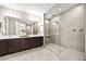 Modern bathroom with double vanity, glass-enclosed shower featuring dual shower heads at 12705 Coastline Shadow St, Las Vegas, NV 89141