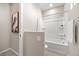 Bathroom featuring shower over tub, neutral tile surround, framed art, and white towel at 12705 Coastline Shadow St, Las Vegas, NV 89141