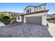 View of a modern two-story home with a paver driveway and attached garage at 12705 Coastline Shadow St, Las Vegas, NV 89141