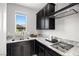 Well-equipped kitchen boasts stainless steel appliances, granite counters, and stylish dark wood cabinetry at 12705 Coastline Shadow St, Las Vegas, NV 89141