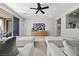 Stylish living room with a large sectional, modern ceiling fan, and sleek wooden console table at 12705 Coastline Shadow St, Las Vegas, NV 89141