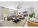 Open-concept living room with modern furniture, a ceiling fan, and sliding glass doors at 12705 Coastline Shadow St, Las Vegas, NV 89141