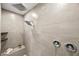 Modern shower featuring dual shower heads, neutral tile surround, and a built-in bench with tiled trim at 12705 Coastline Shadow St, Las Vegas, NV 89141