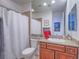Bathroom with granite countertop, cherry-wood vanity, framed mirror, and a shower with a shower curtain at 15 Avenza Dr, Henderson, NV 89011