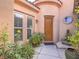 Inviting entryway with a wooden door, decorative plants, and a serene Buddha statue at 15 Avenza Dr, Henderson, NV 89011