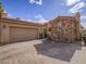 Home with brick driveway, stone details, a two-car garage, and well-maintained landscaping at 15 Avenza Dr, Henderson, NV 89011