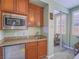 Well-equipped kitchenette with wooden cabinets, granite countertops, microwave, and a mini fridge at 15 Avenza Dr, Henderson, NV 89011