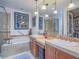 Main bathroom featuring a separate tub, glass-enclosed shower, dual sinks, and a walk-in closet at 15 Avenza Dr, Henderson, NV 89011