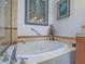 Main bathroom showcasing a jetted tub, tile surround, and framed wall art above the tub at 15 Avenza Dr, Henderson, NV 89011