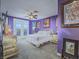Purple-toned main bedroom featuring a ceiling fan, framed wall art, and double doors leading to the backyard at 15 Avenza Dr, Henderson, NV 89011