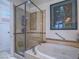 Main bathroom featuring a jetted tub and a glass-enclosed shower with tiled walls and shelving at 15 Avenza Dr, Henderson, NV 89011