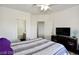 Bright bedroom with ceiling fan, tv, and striped bedding, creating a cozy and inviting atmosphere at 1605 Crimson Hills Dr # 204, Las Vegas, NV 89128