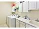 Functional laundry area equipped with a washer, dryer, sink, and overhead cabinets for storage solutions at 1605 Crimson Hills Dr # 204, Las Vegas, NV 89128