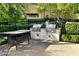 This outdoor kitchen has a double grill, prep area and dining table at 1605 Crimson Hills Dr # 204, Las Vegas, NV 89128