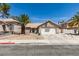 Charming single-story home featuring a two-car garage, desert landscaping and mature palm trees at 1824 Dawn Ridge Ave, Henderson, NV 89074