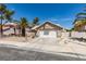 Charming single-story home featuring a two-car garage, desert landscaping and mature palm trees at 1824 Dawn Ridge Ave, Henderson, NV 89074