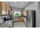 Bright kitchen features stainless steel appliances, light wood cabinets, granite countertops, and tile floor at 2052 Gravel Hill St # 207, Las Vegas, NV 89117