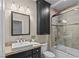 Bathroom featuring granite countertops, a white sink, and updated shower, and dark brown cabinetry at 2215 Bannerwood St, Henderson, NV 89044