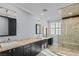 Bathroom featuring an updated shower, granite countertops, mirrors, and dual sinks at 2215 Bannerwood St, Henderson, NV 89044