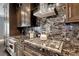 Close-up of the kitchen featuring a gas range, granite countertops, and custom cabinetry at 2215 Bannerwood St, Henderson, NV 89044