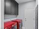 Laundry room featuring red washer and dryer machines and matching upper cabinets at 2215 Bannerwood St, Henderson, NV 89044