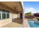 Covered patio area with ceiling fan that overlooks a sparkling swimming pool and lush landscaping at 2215 Bannerwood St, Henderson, NV 89044