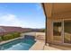 Backyard pool with elevated sundeck, lush landscaping, and views of surrounding mountains at 2215 Bannerwood St, Henderson, NV 89044