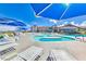 Resort style pool with lounge seating, umbrellas, and luxurious landscaping under a bright, sunny, blue sky at 2215 Bannerwood St, Henderson, NV 89044