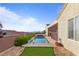 Backyard pool featuring privacy fence, desert landscaping, green turf and mountain views beyond the backyard at 2215 Bannerwood St, Henderson, NV 89044