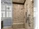 Elegant walk-in shower featuring stone walls, a built-in bench, and sleek chrome fixtures at 2215 Bannerwood St, Henderson, NV 89044